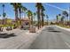 A sunny entrance to a Sun City community, with palm trees lining the road, and mountains in the background at 3012 Anna Bay Dr, Las Vegas, NV 89134