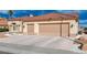 Beige home with a red tile roof and a three car garage with a concrete driveway at 3012 Anna Bay Dr, Las Vegas, NV 89134