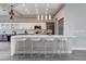 Modern kitchen boasts white cabinets, quartz countertops, mosaic backsplash, and stainless steel appliances at 3012 Anna Bay Dr, Las Vegas, NV 89134