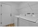 Modern laundry room equipped with a washer, dryer, and overhead shelving for organization at 3109 Siena Cir, Las Vegas, NV 89128