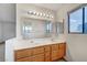 Bathroom featuring double sinks, wood cabinets, and a large mirror with vanity lighting at 3152 Centavo Dr, Las Vegas, NV 89117
