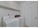 Functional laundry room features a washer, dryer, and storage shelving at 3152 Centavo Dr, Las Vegas, NV 89117