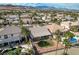 Aerial shot revealing houses with pools, palm trees, mountains, and a serene backyard setting at 33 Chateau Whistler Ct, Las Vegas, NV 89148
