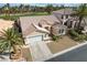 Charming front elevation showcasing a lovely home, two-car garage, a mature palm tree, and desert landscaping at 33 Chateau Whistler Ct, Las Vegas, NV 89148