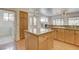 Well-lit kitchen featuring a central island, granite countertops, and wood cabinets at 33 Chateau Whistler Ct, Las Vegas, NV 89148