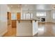 Open-concept kitchen with central island, wood floors, and views to the living room and fireplace at 33 Chateau Whistler Ct, Las Vegas, NV 89148
