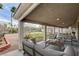Inviting covered patio with outdoor seating, a grassy backyard, and lovely palm trees at 33 Chateau Whistler Ct, Las Vegas, NV 89148