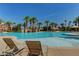 Poolside view with lounge chairs overlooking a large pool, palm trees, and a nearby waterpark at 33 Chateau Whistler Ct, Las Vegas, NV 89148