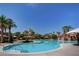 Luxurious swimming pool surrounded by lush landscaping, palm trees, and shaded seating areas, perfect for relaxation at 33 Chateau Whistler Ct, Las Vegas, NV 89148