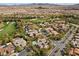 Aerial view showcases a community with homes near a golf course with mountain views in the distance at 3680 Belvedere Park Ln, Las Vegas, NV 89141