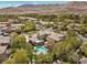 Aerial image of a beautiful home with a pool, surrounded by lush greenery and desert landscape at 3680 Belvedere Park Ln, Las Vegas, NV 89141