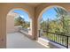 A covered balcony with decorative arches overlooking lush greenery at 3680 Belvedere Park Ln, Las Vegas, NV 89141