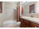 Bathroom featuring a single sink, wood vanity, and shower-tub combo with neutral tiling at 3680 Belvedere Park Ln, Las Vegas, NV 89141