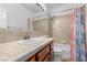 Bathroom with a single sink, wooden vanity, and shower-tub combo with beige tiling at 3680 Belvedere Park Ln, Las Vegas, NV 89141
