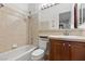 Bathroom with a single sink, wood vanity, and shower-tub combo with beige tiling at 3680 Belvedere Park Ln, Las Vegas, NV 89141