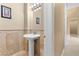 Neutral powder room with pedestal sink, decorative tile, and a framed mirror at 3680 Belvedere Park Ln, Las Vegas, NV 89141