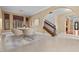 Elegant dining area with a modern table, plush chairs, and staircase access, bathed in natural light at 3680 Belvedere Park Ln, Las Vegas, NV 89141