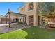 An exterior view of the residence highlights the outdoor seating, patio, and manicured lawn at 3680 Belvedere Park Ln, Las Vegas, NV 89141