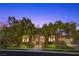 Stunning home exterior featuring a wrought iron gate and mature landscaping at dusk at 3680 Belvedere Park Ln, Las Vegas, NV 89141