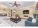 Inviting living room with a fireplace, hardwood floors, comfortable seating, and views to other rooms at 3680 Belvedere Park Ln, Las Vegas, NV 89141