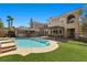 Backyard with a pool, grass turf, covered patio, and a well maintained desert landscape at 3680 Belvedere Park Ln, Las Vegas, NV 89141