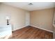 A tan-painted bedroom featuring wood floors, a white door, and a small white bookcase at 3905 E Cherokee Ave, Las Vegas, NV 89121