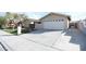 Tan single-story home featuring a two-car garage and a well-maintained lawn with mature landscaping at 3905 E Cherokee Ave, Las Vegas, NV 89121