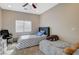Bright bedroom featuring two beds with blue accents, a ceiling fan, and a black office chair at 4459 S Glory Vine Ln, Pahrump, NV 89061