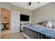 Cozy bedroom featuring a mounted TV, white dresser, neutral walls, and comfy-looking bed with blue accents at 4459 S Glory Vine Ln, Pahrump, NV 89061