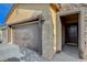 Inviting entryway of a home with a two-car garage, stone accents, and a well-lit porch, offering great curb appeal at 4459 S Glory Vine Ln, Pahrump, NV 89061