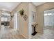 Bright hallway featuring wood-look tile floors, stylish decor, and a view into the living area and bathroom at 4459 S Glory Vine Ln, Pahrump, NV 89061