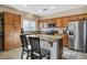 Well-lit kitchen with granite island, stainless steel appliances, and wood cabinets offer a modern and functional space at 4459 S Glory Vine Ln, Pahrump, NV 89061