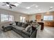 Bright living room featuring a large sectional sofa, a sliding glass door to the outside, and an open kitchen layout at 4459 S Glory Vine Ln, Pahrump, NV 89061