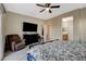 A carpeted bedroom includes a ceiling fan, a TV, and doorways to the Primary bathroom and hallway at 4459 S Glory Vine Ln, Pahrump, NV 89061