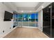 Modern bedroom boasting expansive windows with vibrant cityscape views, a mounted tv and sleek closet doors at 4525 Dean Martin Dr # 511, Las Vegas, NV 89103