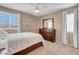 Comfortable bedroom with a queen bed, wood dresser, and two sunny windows at 4647 Stearman Dr, North Las Vegas, NV 89031