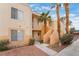 Exterior view of condo building featuring stucco facade, balconies, and mature palm trees at 5000 Red Rock St # 120, Las Vegas, NV 89118