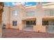 Exterior view of a two-story condo showcasing balconies and manicured landscaping, set on a gravel lot at 5000 Red Rock St # 120, Las Vegas, NV 89118