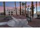 Exterior view of apartments surrounded by mature palm trees, benches, and sidewalks with beautiful landscaping at 5000 Red Rock St # 120, Las Vegas, NV 89118