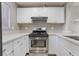 Kitchen area featuring stainless steel oven and hood over white cabinetry at 5000 Red Rock St # 120, Las Vegas, NV 89118