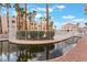 Community pool and pond area with palm trees and clubhouse, ideal for relaxation and neighborhood social gatherings at 5000 Red Rock St # 120, Las Vegas, NV 89118