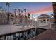 Community pool and clubhouse with palm trees, creating a luxurious and relaxing atmosphere at dusk at 5000 Red Rock St # 120, Las Vegas, NV 89118