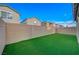 Low maintenance backyard featuring green artificial turf and a tall privacy wall at 5040 Serene Skies St, Las Vegas, NV 89130