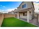 Enjoy this backyard featuring green artificial turf, a covered patio, a brick walkway, and a privacy wall at 5040 Serene Skies St, Las Vegas, NV 89130