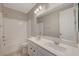 Bathroom featuring dual sink vanity and tub with white tile surround at 5040 Serene Skies St, Las Vegas, NV 89130