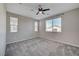 Large bedroom with neutral carpet, ceiling fan, and bright windows at 5040 Serene Skies St, Las Vegas, NV 89130