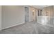Upstairs loft space with neutral carpet, railing, and view into the bathroom at 5040 Serene Skies St, Las Vegas, NV 89130