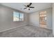 Spacious main bedroom featuring neutral paint, plush carpet, ceiling fan, and an ensuite bathroom at 5040 Serene Skies St, Las Vegas, NV 89130