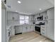 Bright kitchen featuring stainless steel appliances, white cabinets, and hardwood-style floors at 5508 Kettering Pl, Las Vegas, NV 89107