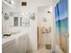 Bright bathroom featuring a single sink, mirrors, and a beach-themed shower curtain at 5706 W Lake Mead Blvd, Las Vegas, NV 89108